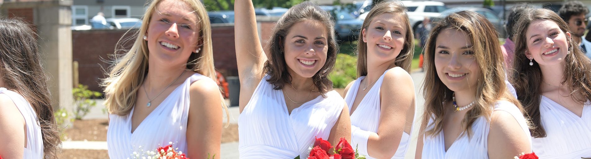 Students with white dresses and flowers